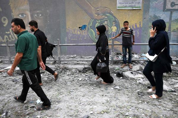 Palestinians evacuate their homes after Israeli strikes on Gaza City on October 9, 2023. —AFP)