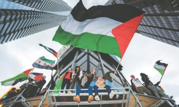  TORONTO: Demo<em></em>nstrators wave Palestinian flags during a protest in Canada on Tuesday. — AFP 