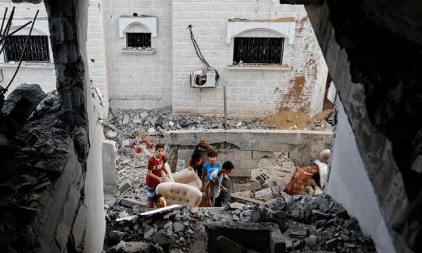  Palestinian boys carry belo<em></em>ngings on the rubble near a damaged house, following Israeli strikes, in Khan Younis in the southern Gaza Strip October 11, 2023.  — Reuters 