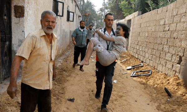  A man carries a wounded Palestinian girl at the site of Israeli strikes on houses, in Khan Younis in the southern Gaza Strip on October 11, 2023. — Reuters 