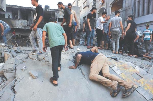  Gaza City: Palestinians look for survivors under the rubble of a building following an Israeli air strike as bombing of the besieged enclave co<em></em>ntinued for the fifth co<em></em>nsecutive day, on Wednesday.—AFP 